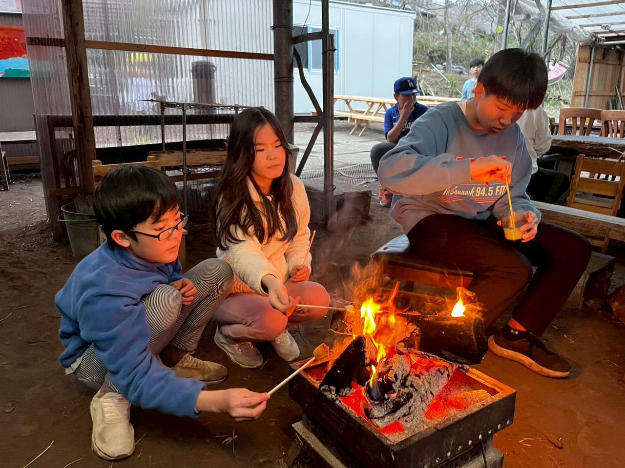 小さな焚火を囲んで過ごす子どもたち